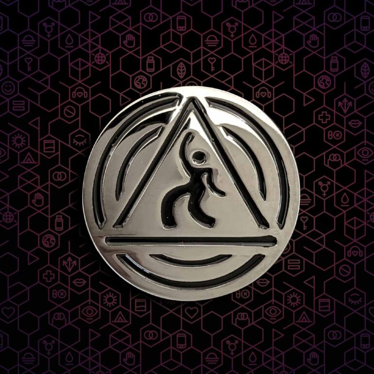 A silver DanceSafe logo pin on a black and hexagonal background.