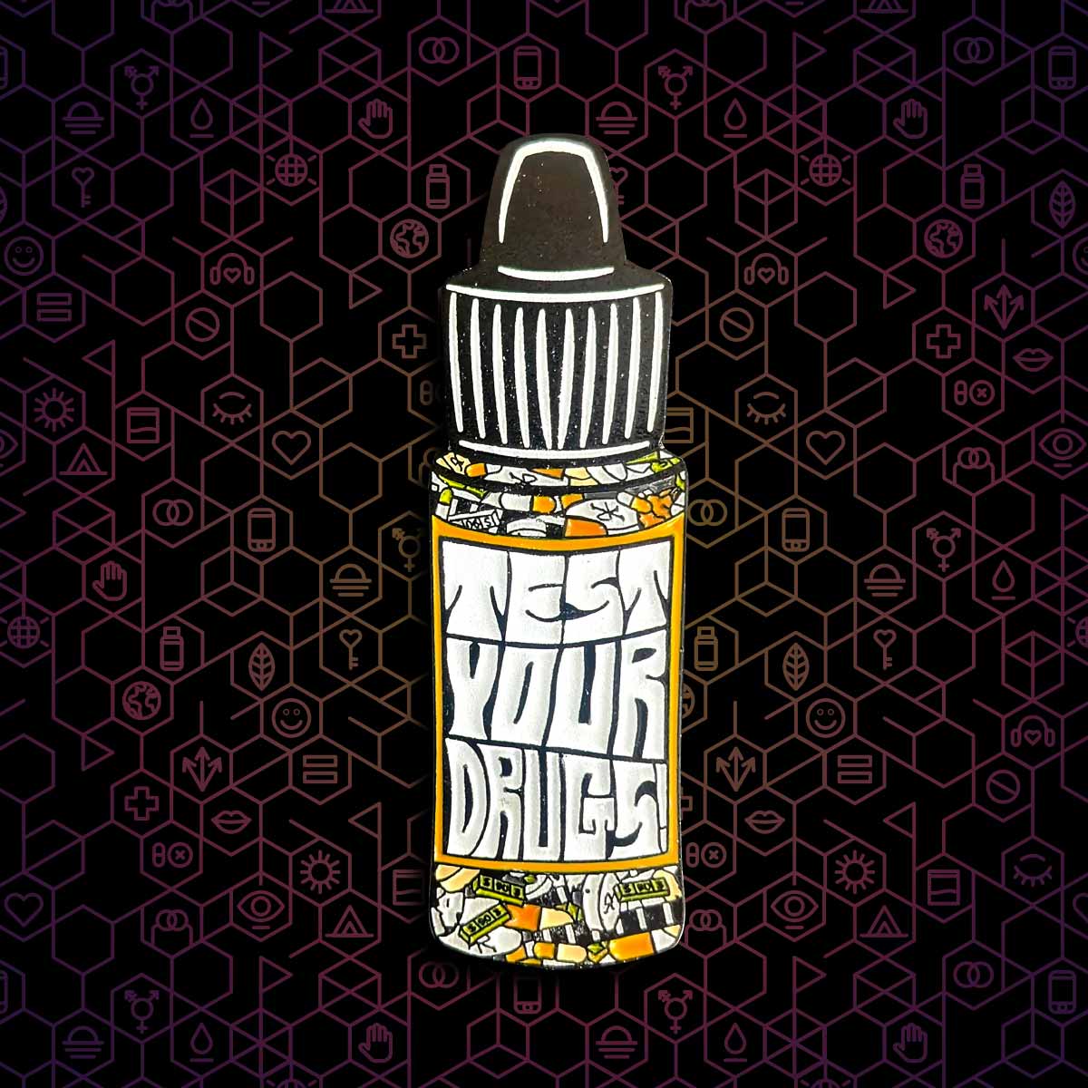 Reagent bottle-shaped pin that says "Test your drugs" on a dark hexagonal background.