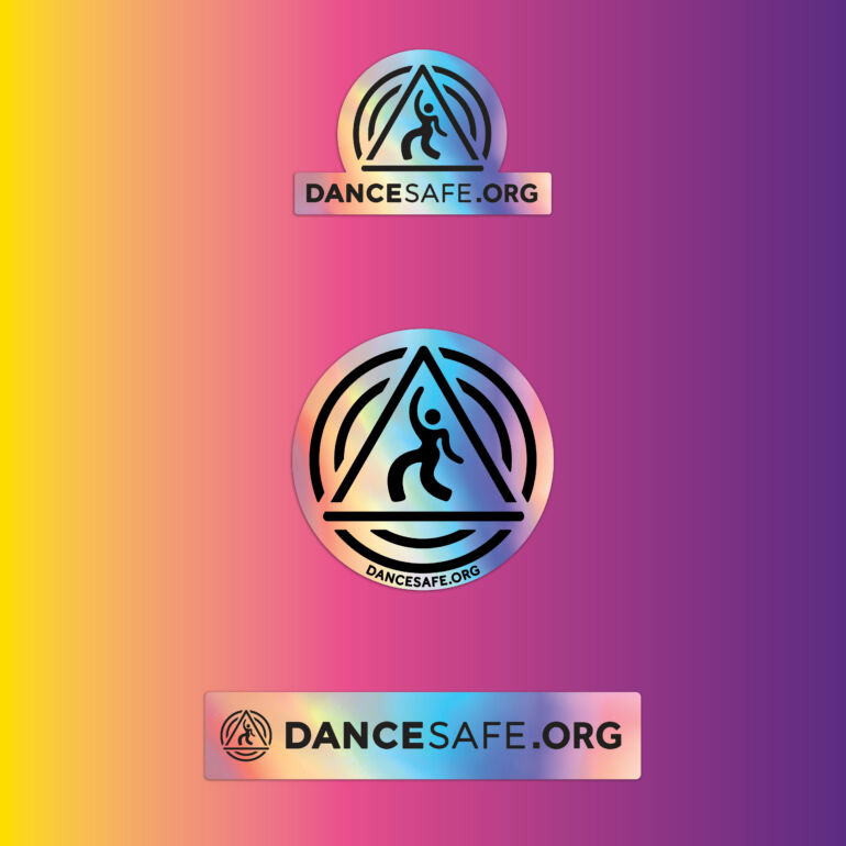 Set of holographic DanceSafe stickers with iridescent rainbow tones displayed on a warm gradient background, featuring circular, rectangular, and arch-shaped “DANCESAFE.ORG” designs.